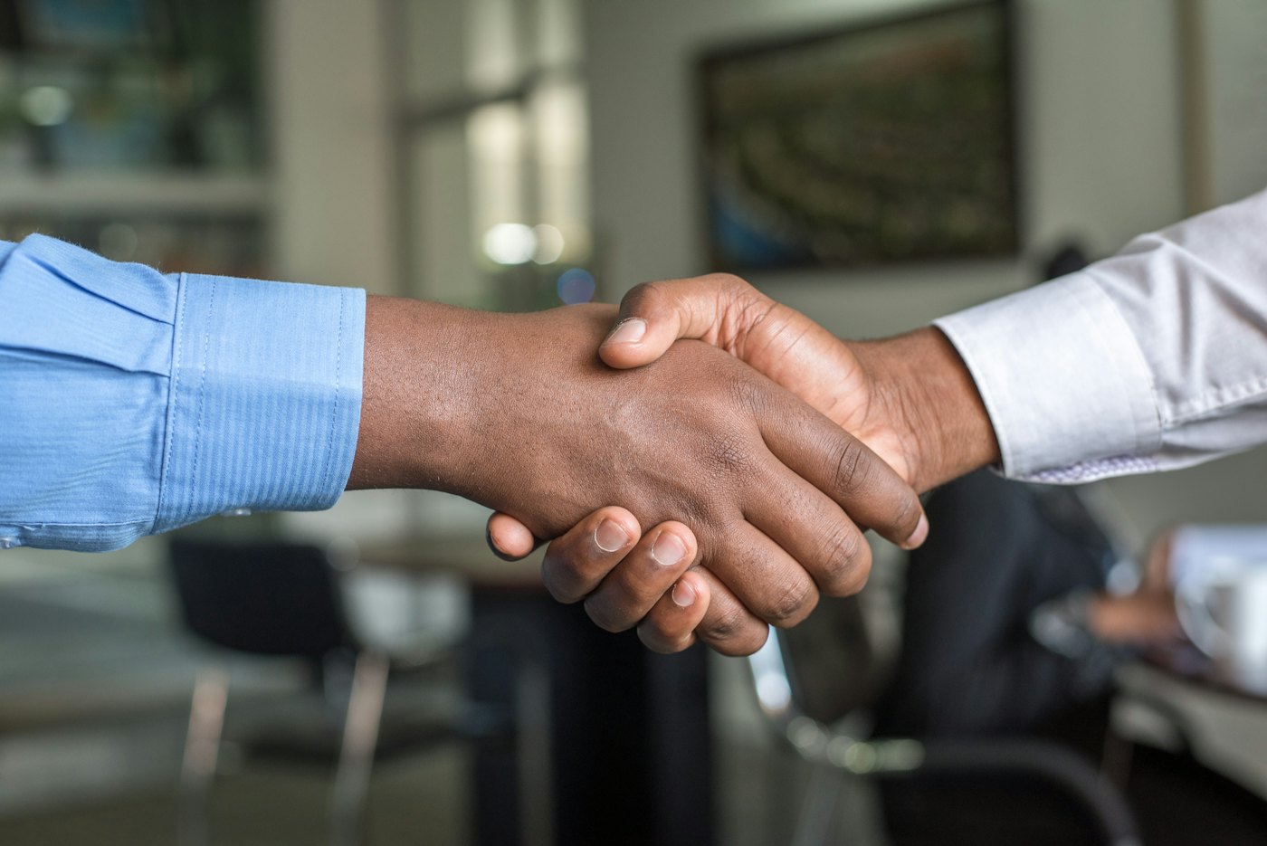 Two professionals shaking hands across a desk